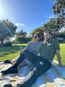 Man and woman sitting down at park wearing solstice gear